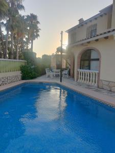 een blauw zwembad voor een huis bij Estudios privados en Villa con piscina privada in Els Poblets