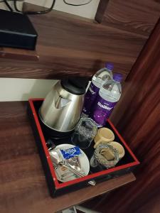 eine Schublade mit einer Kaffeekanne, Wasser und anderen Artikeln in der Unterkunft HOTEL GOLDEN TULIPZ in Mumbai
