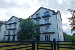 ブワディスワボボにあるMieszkanie Słoneczne Reja 2Bの前に柵がある白い建物