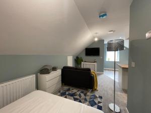 a room with a bed and a couch and a tv at Silk Apartments Spondon in Derby