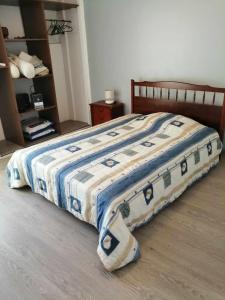 Una cama con una manta azul y blanca. en Chez Denis et Lucie, en Saint-André