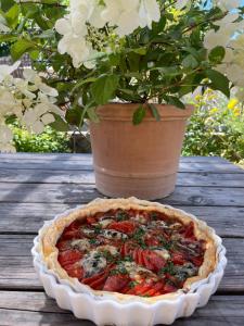 une tarte assise sur une table à côté d'une plante en pot dans l'établissement Une envie de montagne, à Guillestre