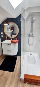 een badkamer met een douche, een wastafel en een spiegel bij Bleu - Éden - appartement moderne en hypercentre in Vichy