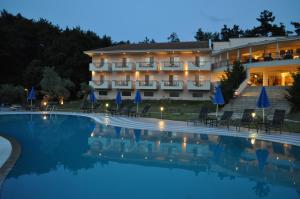 a hotel with a swimming pool at night at Kohylia by La Scala Beach in Limenas