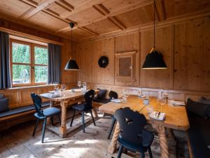 uma sala de jantar com paredes e mesas e cadeiras de madeira em Berghotel Sonnenbichl em Bad Wiessee