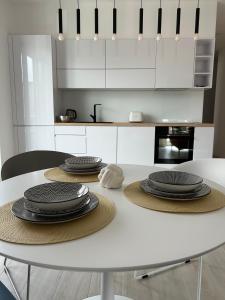 eine weiße Küche mit einem Tisch mit Tellern darauf in der Unterkunft Aurus 2 in Korčula
