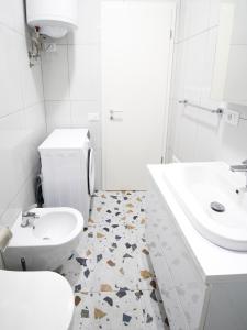 a white bathroom with a toilet and a sink at Modern Apt in Mangalem21 Complex WiFi,AC in Tirana