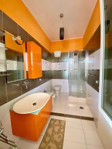 baño de color naranja con lavabo y aseo en Villa Liberti, en Castellabate