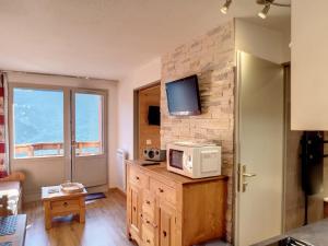a living room with a microwave on a brick wall at Appartement Confort 1 chambre, ski aux pieds, balcon, Wi-Fi, parking - FR-1-178-171 in Les Bruyères