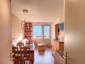 a kitchen with a table and a dining room at Appartement Confort 1 chambre, ski aux pieds, balcon, Wi-Fi, parking - FR-1-178-171 in Les Bruyères