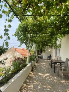 un patio con mesas, sillas y árboles en Guest House Luce, en Dubrovnik