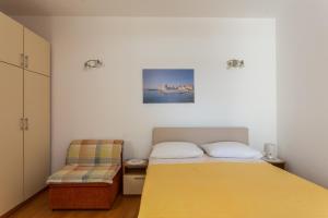 1 dormitorio con 1 cama amarilla y 1 silla en Guest House Luce, en Dubrovnik