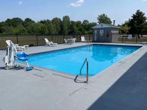 a swimming pool with chairs and a table and chairs at Sleep Inn DeWitt in DeWitt