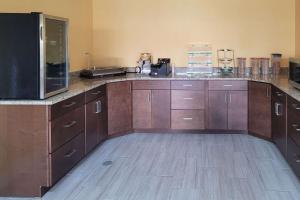 cocina grande con armarios de madera y nevera en Quality Inn, en Tifton