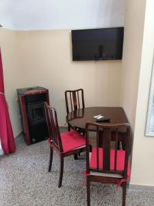 a room with a table and chairs and a television at La Torre della Piramide in Pitigliano