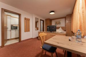 a kitchen with a table and a desk with a television at Alpenliebe in Sölden