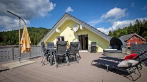 eine Terrasse mit Stühlen, einem Tisch und einem Haus in der Unterkunft Ferienwohnung Mayer in Schluchsee