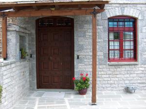 a wooden door with a plant in front of a building at Villa Georgia in Vitsa