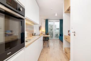 a kitchen with a sink and a microwave at Saska Blu Studio Apartments Podgórze by Renters in Krakow