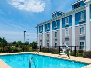 a building with a swimming pool in front of a building at Comfort Inn West Monroe near Sports & Events Center in West Monroe