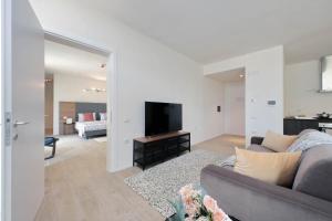 a living room with a couch and a flat screen tv at Siena Hills Apartments in Siena +87 photos
