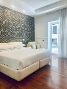 1 cama blanca grande en un dormitorio con pared en Napoliday, en Nápoles