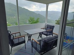 balcón con mesa, sillas y montañas en wonderful villa en Dolaylı