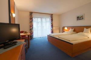 um quarto de hotel com uma cama e uma televisão de ecrã plano em Trip Inn Aktivhotel & Restaurant Sonnenhof bei Passau em Sonnen