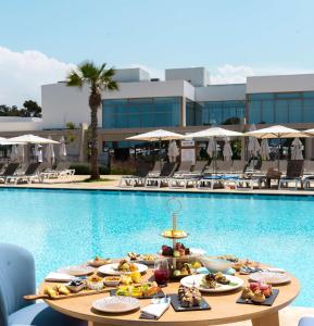 una mesa con comida junto a una piscina en Radisson Blu Resort Al Hoceima en Alhucemas