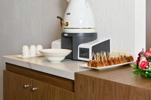 a counter with a coffee maker and a plate of pastries at Comfort Hotel Jeddah King Road in Jeddah