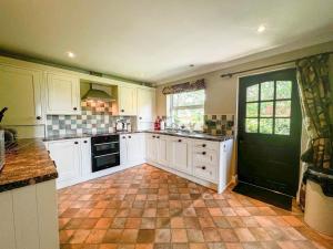 a kitchen with white cabinets and a tile floor at Geltsdale Garden Apartment ground floor home in Wetheral close to Carlisle & Ullswater in Wetheral