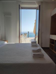 a bedroom with a bed and a view of the ocean at Hotel Due Gemelli in Riomaggiore