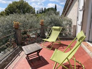 2 grüne Stühle und ein Tisch auf der Terrasse in der Unterkunft Belle villa de charme avec piscine in Tourrettes