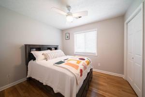 1 dormitorio con 1 cama y ventilador de techo en Cozy Brick Ranch Home owned and operated by an Army Soldier!! en Columbus