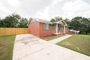 una casa de ladrillo rojo con una valla en un patio en Cozy Brick Ranch Home owned and operated by an Army Soldier!! en Columbus