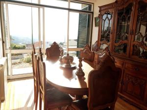 uma mesa de madeira num quarto com uma grande janela em Casa da Estrela em Seia