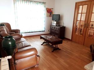 uma sala de estar com um sofá de couro e uma mesa de centro em Casa da Estrela em Seia