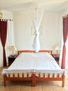 1 dormitorio con 1 cama blanca grande con cortinas en Fox Apartments, en Cavtat