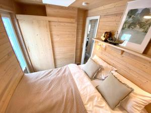 una camera con un letto in una stanza con pareti in legno di Hausboot Yara am Steg 1D a Heiligenhafen