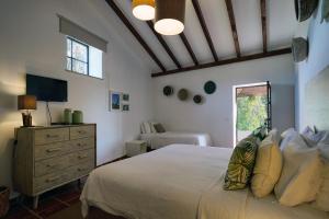 a bedroom with a bed and a dresser and a window at Vale Fuzeiros Nature Guest House in Vale Fuzeiros