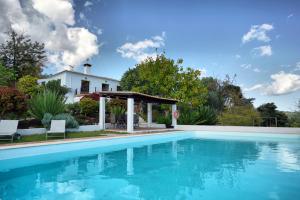 a swimming pool with a gazebo and a house at Vale Fuzeiros Nature Guest House in Vale Fuzeiros