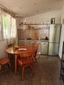 eine Küche mit Holztisch und Kühlschrank in der Unterkunft Quiet apartment in a private house - close to center, parking, pet friendly in Split