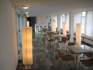 uma sala de jantar com mesas, cadeiras e luzes em Albergo dei Pini em Andria