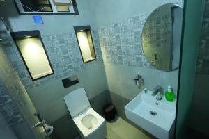 a bathroom with a sink and a toilet and a mirror at BIGSON SERVICE APARTMENTS MADHAPUR in Hyderabad