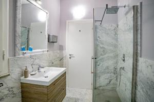 y baño con lavabo y ducha. en Elegante camera con finiture di lusso appena ristrutturata en Marina di Carrara