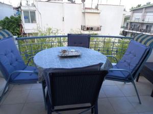 a blue table and chairs on a balcony at Anastasia's Apartment 2 in Néa Péramos