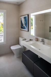 La salle de bains est pourvue d'un lavabo, de toilettes et d'un miroir. dans l'établissement SUNRISE by Buenavilla, à Playa Blanca