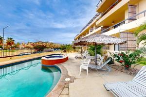 una piscina con mesa, sillas y sombrilla en La Costa Beautiful Golf Villa en San José del Cabo