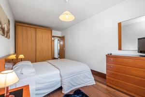 1 dormitorio con 1 cama y vestidor con TV en EDU FLAT, en Machico