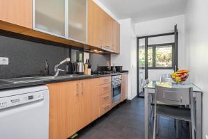 a kitchen with wooden cabinets and a counter top at EDU FLAT in Machico